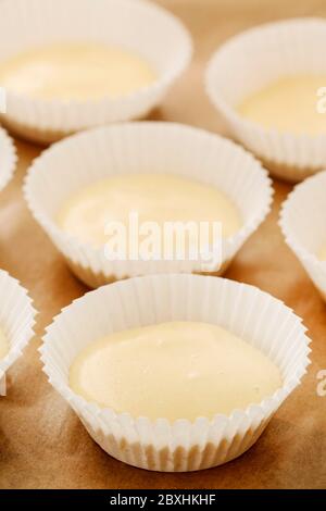 Impasto di cupcake in stampi di carta. Dolci preparati per la cottura. Dessert per feste Foto Stock