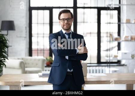 Ritratto di uomo d'affari sorridente in posa in ufficio moderno Foto Stock