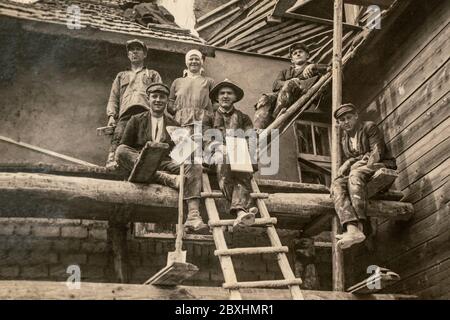 Lettonia - CIRCA 1920: Foto di costruttori che lavorano sul sito. Seduto su un ponteggio. Archivio di fotografie in bianco e nero vintage Foto Stock