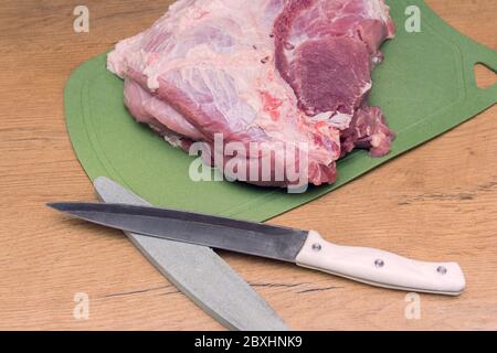 Affettare la carne di maiale a pezzetto. Cucina piatti di carne. Carne di maiale su un tagliere Foto Stock
