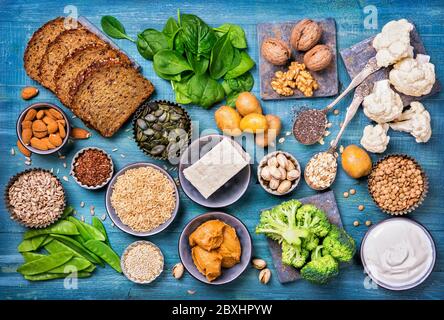 Fonti di proteina vegana. Vista dall'alto su sfondo blu in legno Foto Stock