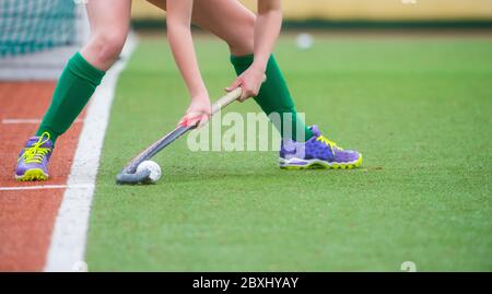 Giocatore di hockey da campo, pronto a passare la palla a un compagno di squadra. Hockey è una partita di squadra Foto Stock