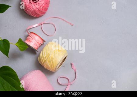 Filati diversi su sfondo grigio neutro. Immagine con spazio di copia, vista dall'alto. Concetto di hobby domestico Foto Stock