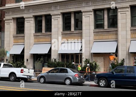 Los Angeles, CA/USA - 1 giugno 2020: Lavoratori che si imbarcano in una finestra di un business nel quartiere del teatro danneggiato durante le rivolte Black Lives Matter su M. Foto Stock