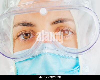 Ritratto di una donna caucasica che indossa tuta, maschera e occhiali in ospedale. Coronavirus, Covid-19, epidemia globale, maschera medica, ospedale, Foto Stock