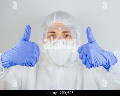 Il medico mostra un gesto di fiducia. Fidarsi del paziente per l'epidemia di COVID-19. Allegro medico in laboratorio per la prevenzione del coronavirus. Wuhan, CH Foto Stock