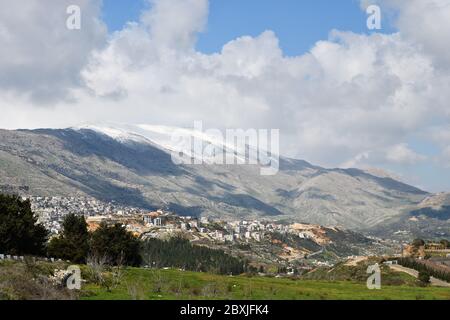 Monte Hermon coperto di neve e il villaggio di Druze di Majdal Shams nelle alture del Golan nel Nord Israele Foto Stock