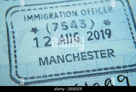 Timbro di entrata sul passaporto rilasciato dall'agente dell'immigrazione alla frontiera e controllo dei visti all'aeroporto di Manchester nel Regno Unito. Messa a fuoco selettiva. Foto macro. Foto Stock