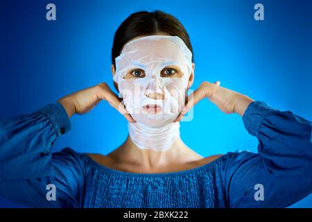 donna mostra come applicare una maschera di bellezza al tuo viso Foto Stock