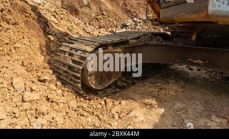 Ruote dell'escavatore con terreno collegato. Il processo di manutenzione è necessario per migliorare le prestazioni Foto Stock
