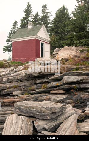 Scarico di olio, utilizzato per immagazzinare l'olio del faro, seduto sulle rocce, situato al faro di Pemaquid Point a Bristol, Maine. Foto Stock