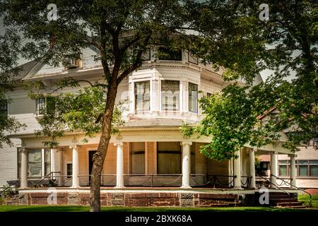 Una vecchia casa a tre piani in stile architettonico Queen Anne con veranda avvolgente e dettagli ringhiera a catena a St. Cloud, Minnesota, USA Foto Stock