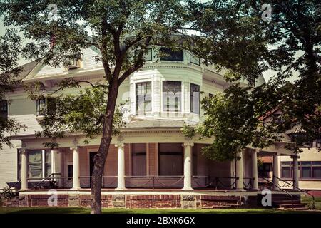 Una vecchia casa a tre piani in stile architettonico Queen Anne con veranda avvolgente e dettagli ringhiera a catena a St. Cloud, Minnesota, USA Foto Stock