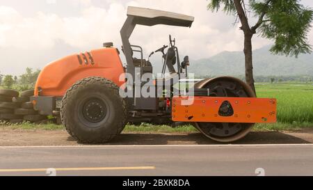 Vibrazione rullo stradale monocilindrico che livella il terreno per la fondazione. Compattatore per terreno per la posa di asfalto su strada in cantiere. COM. Strada Foto Stock