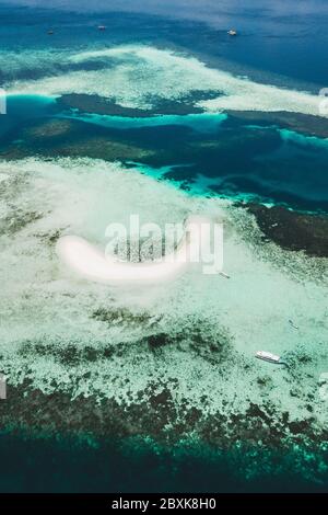 Vista aerea dell'isola di Taka Makassar nel parco nazionale di Komodo, Indonesia. Paradiso vuoto piccola isola di sabbia bianca sulla barriera corallina. Foto Stock