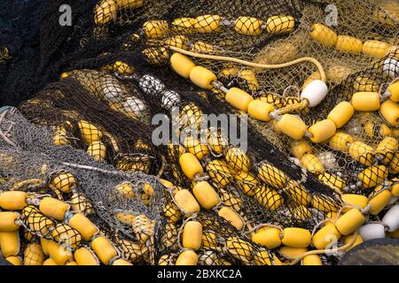 Mucchio di reti da pesca con boe gialle e bianche Foto Stock