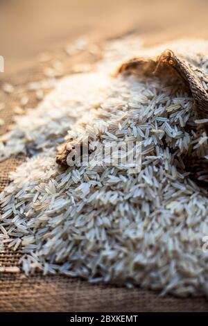Primo piano di riso bianco Basmati grezzo in una borsa di colore marrone. Foto Stock