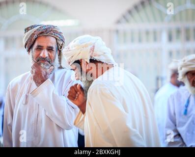 Nizwa, Oman, 2 dicembre 2016: Gli uomini locali che acquistano al mercato della capra di venerdì a Nizwa, Oman Foto Stock