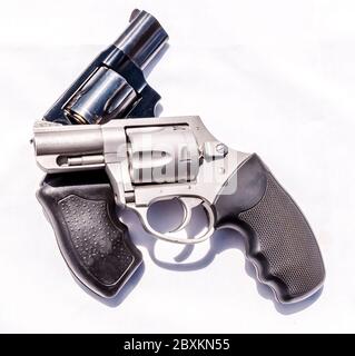 Due pistole, una in acciaio inox 357 e una speciale revolver nera 38 su sfondo bianco Foto Stock