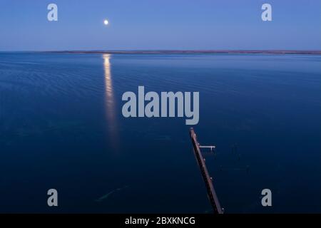 La luna si riflette nell'oceano e nel molo di Ceduna in Australia del Sud Foto Stock