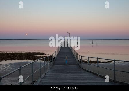 La luna e il molo a Ceduna in Australia del Sud all'alba Foto Stock