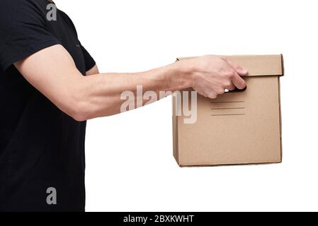 Uomo di consegna in t-shirt nera tenere scatola di cartone su sfondo bianco isolato. Concetto di servizio di consegna Foto Stock