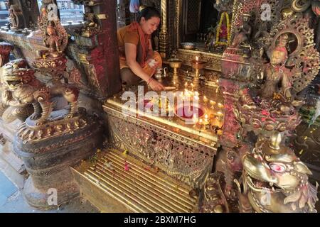 Una sacerdotessa che officiava in un santuario di Hiranya Varna Mahavihar, anche Kwa Bahal o Tempio d'oro, a Patan (Lalitpur), Valle di Kathmandu, Nepal Foto Stock