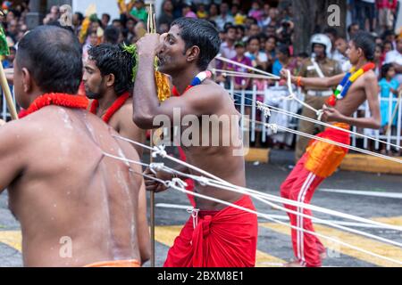 Un ballerino Kavadi (indù) con una serie di piercing corpo si muove attraverso le strade di Kandy in Sri Lanka durante il giorno Perahera. Foto Stock