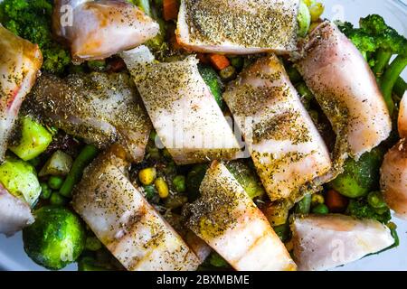 Pesce sano al forno con verdure, filetto di merluzzo fritto con lattuga e verdure da vicino, fuoco selettivo, spezie cavoli di bruxelles, vegetariano Foto Stock