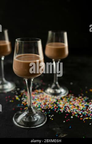 fuoco selettivo: cioccolato e liquore di caffè in un alto stack su un tavolo scuro Foto Stock
