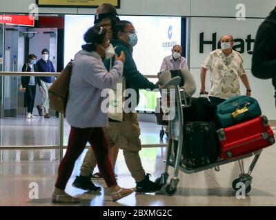 I passeggeri arrivano al Terminal 2 dell'aeroporto di Heathrow a Londra, quando entrano in vigore le nuove misure di quarantena per gli arrivi internazionali. Foto Stock