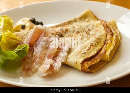 Gravlax con pancake servita foglie di insalata Foto Stock