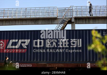 (200608) -- PECHINO, 8 giugno 2020 (Xinhua) -- UN poliziotto controlla un treno merci in uscita Cina-Europa al Passo Horgos nella regione autonoma di Xinjiang Uygur, 20 aprile 2020. Avviato nel 2011, il servizio di trasporto ferroviario Cina-Europa è considerato una parte significativa dell'iniziativa Belt and Road per incentivare gli scambi commerciali tra la Cina e i paesi partecipanti al programma. In mezzo alla pandemia del coronavirus, il servizio è rimasto un canale di trasporto affidabile in quanto il trasporto aereo, marittimo e stradale sono stati gravemente colpiti. Anche i treni merci hanno svolto un ruolo cruciale in questo settore Foto Stock