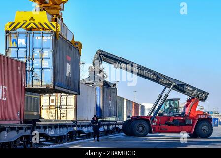 (200608) -- PECHINO, 8 giugno 2020 (Xinhua) -- i lavoratori caricano un container su un treno presso il Centro espresso ferroviario Cina-Europa di Urumqi, capitale della regione autonoma Xinjiang Uygur, 12 marzo 2020. Avviato nel 2011, il servizio di trasporto ferroviario Cina-Europa è considerato una parte significativa dell'iniziativa Belt and Road per incentivare gli scambi commerciali tra la Cina e i paesi partecipanti al programma. In mezzo alla pandemia del coronavirus, il servizio è rimasto un canale di trasporto affidabile in quanto il trasporto aereo, marittimo e stradale sono stati gravemente colpiti. Anche i treni merci lo sono stati Foto Stock