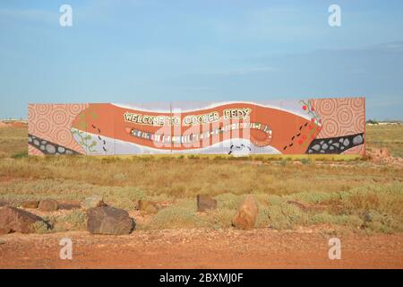 Cartello dipinto a lungo in stile aborigeno all'ingresso della cittadina estrattiva opalica di Coober Pedy, in Australia Foto Stock