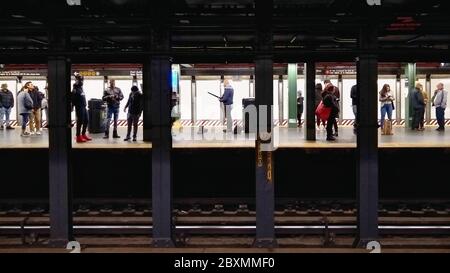 Persone che aspettano il treno A presso una stazione della metropolitana a New York City Foto Stock