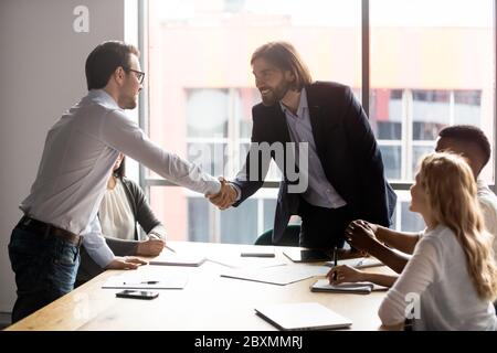 La negoziazione inizia con i leader dei partiti aziendali che si scuotono le mani Foto Stock