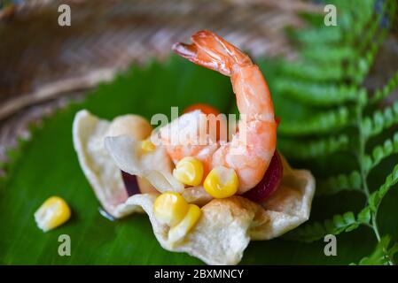 insalata di gamberi mais e salsa su cracker di gamberi con sfondo di foglie di banana cibo asiatico in tailandese / delizioso menu gamberetti gamberetti cucinati Foto Stock