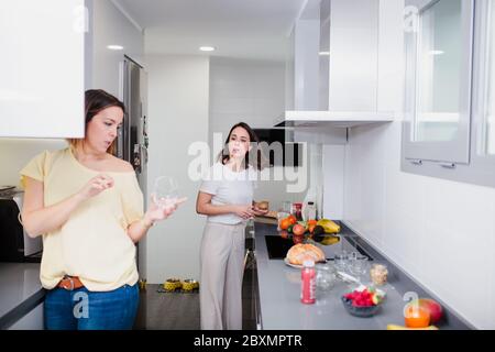 Amici allegri che cucinano cibo di qualità nella cucina casalinga Foto Stock