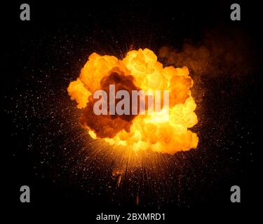 Esplosione di una bomba fiery con scintille isolate su sfondo nero. Texture fotografia di fuoco e fumo. Foto Stock