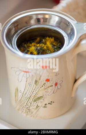 Concetto fai da te. Tazza decorativa in ceramica fatta a mano con tè alle erbe... Foto Stock