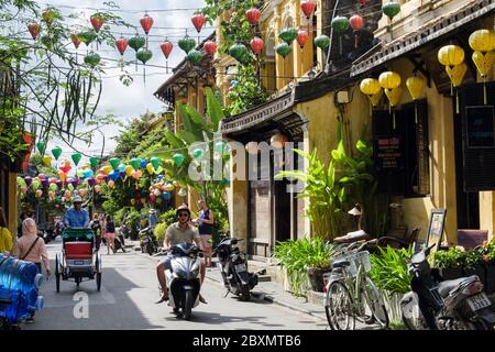 Lanterne appese su una strada stretta trafficata di gente nel quartiere vecchio della città storica. Hoi An, Provincia di Quang Nam, Vietnam, Asia sudorientale Foto Stock