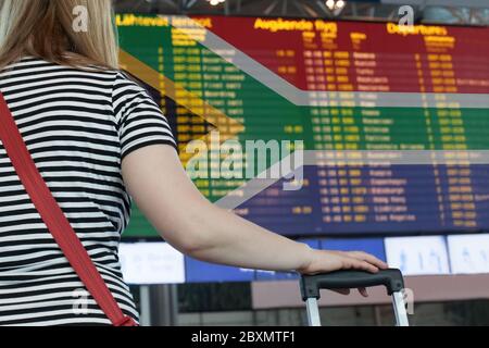 Donna guarda il tabellone di valutazione all'aeroporto. Selezionare un paese Repubblica del Sudafrica per viaggi o migrazioni. Foto Stock