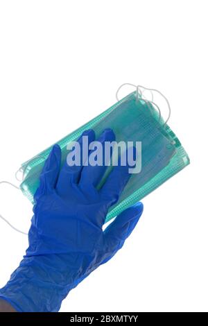 Maschere mediche e guanti isolati su uno sfondo bianco.UNA mano in un guanto blu contiene un pacchetto di maschere antivirus mediche set. Foto Stock