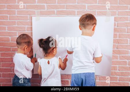 I bambini piccoli si attingono alla carta, alla scuola domestica, all'istruzione prescolare Foto Stock