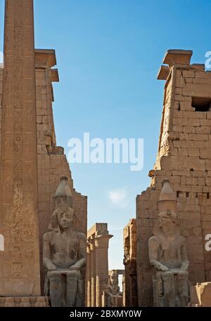 Grandi sculture di Ramses II all'ingresso del pilone all'antico tempio egiziano di Luxor Foto Stock