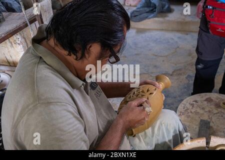 Uomo che intaglia un contenitore di acqua di argilla in un laboratorio di ceramica a Kuala, Kangsar, Perak, Malesia Foto Stock