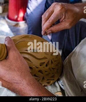 Uomo che intaglia un contenitore di acqua di argilla in un laboratorio di ceramica a Kuala, Kangsar, Perak, Malesia Foto Stock