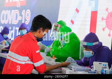 Giacarta, Indonesia. 8 giugno 2020. Health worker Perform preleva un campione di sangue da un uomo durante un programma di test anticorpale del coronavirus a Giacarta, Indonesia, 8 giugno 2020. (Foto di Evan Prasditya/INA Photo Agency/Sipa USA) Credit: Sipa USA/Alamy Live News Foto Stock