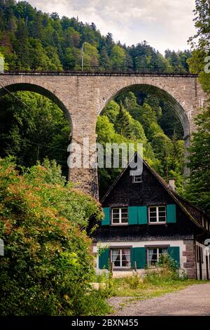 Breitnau, Baden-Württemberg, Germania - Luglio 27 2019 : Casa tradizionale nella Foresta Nera tedesca con tetto in legno, persiane verdi. Il 37 m hi Foto Stock